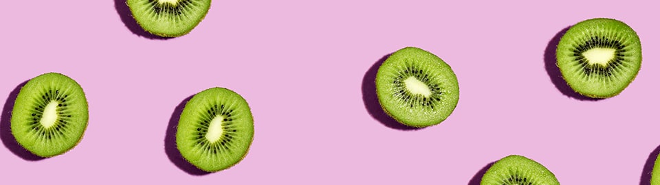 kiwi slices on a pink background