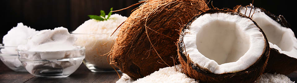 coconuts next to coconut oil in a bowl