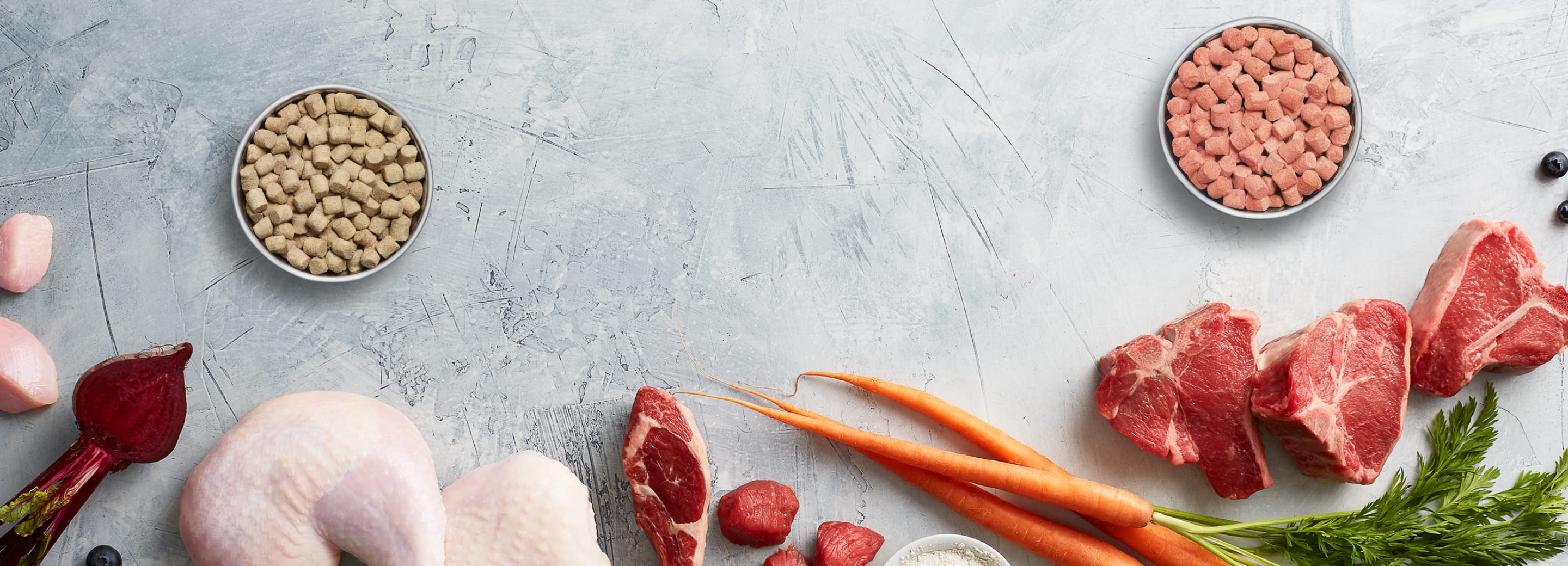 Instinct, the Raw Brand logo and images of raw meat and vegetable ingredients used to make pet food.