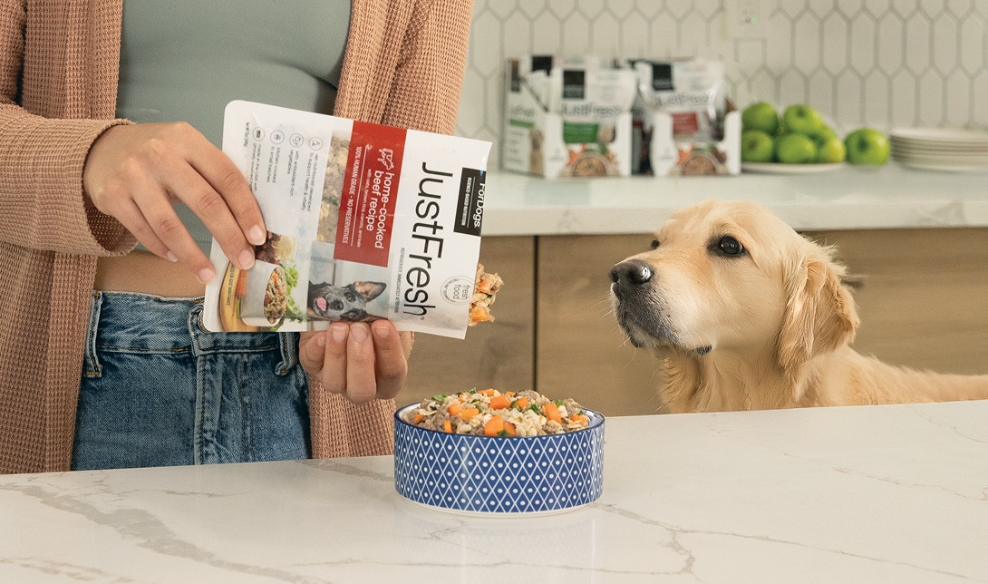 A dog being served Just Food For Dogs kibbles.